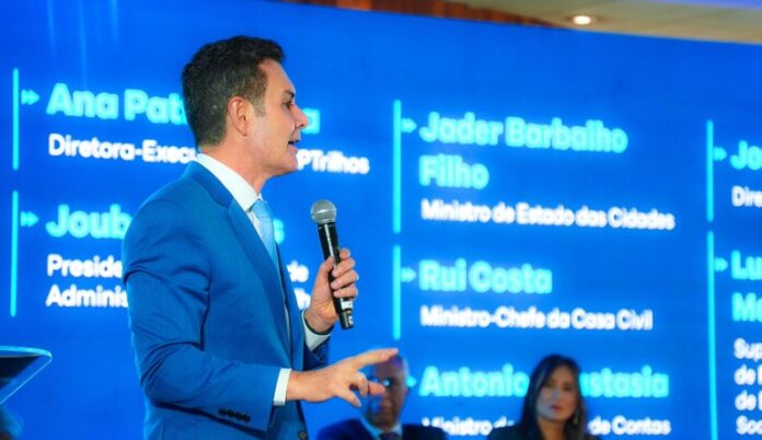 Homem com microfone falando em evento sobre mobilidade urbana