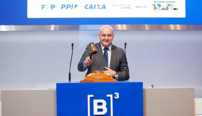 Na imagem homem batendo martelo de leilão de empresas de iluminação pública