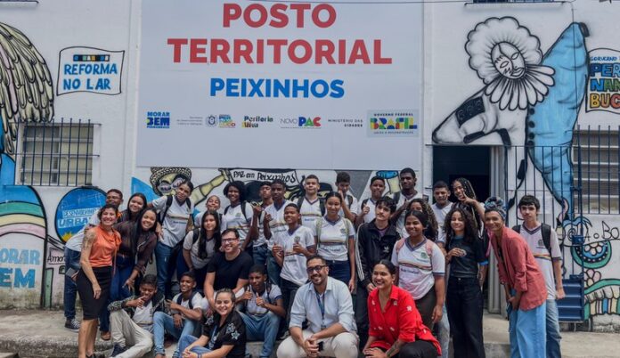 Na imagem pessoas sorrindo para fotografo, ao fundo Posto Territorial de comunidade em Pernambuco